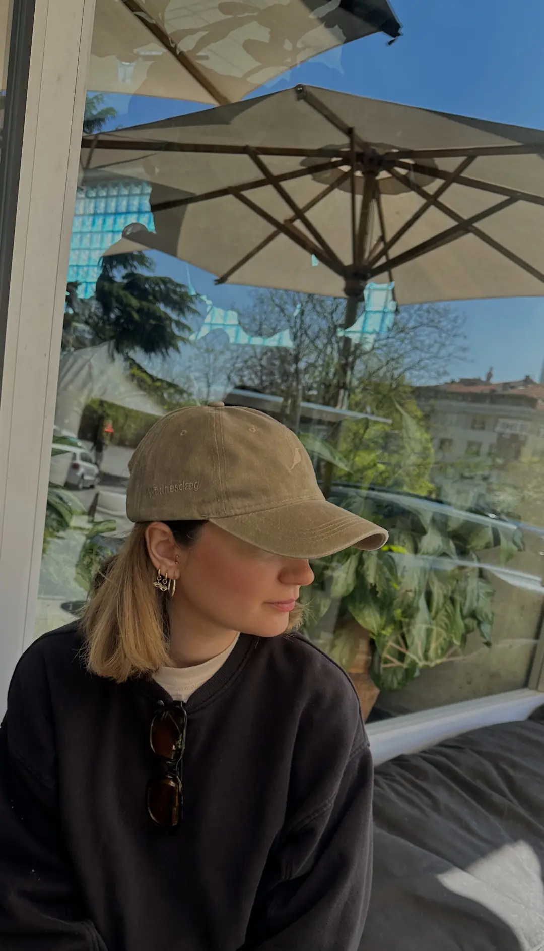 Kafe terasında Trace Cap Ash giyen model