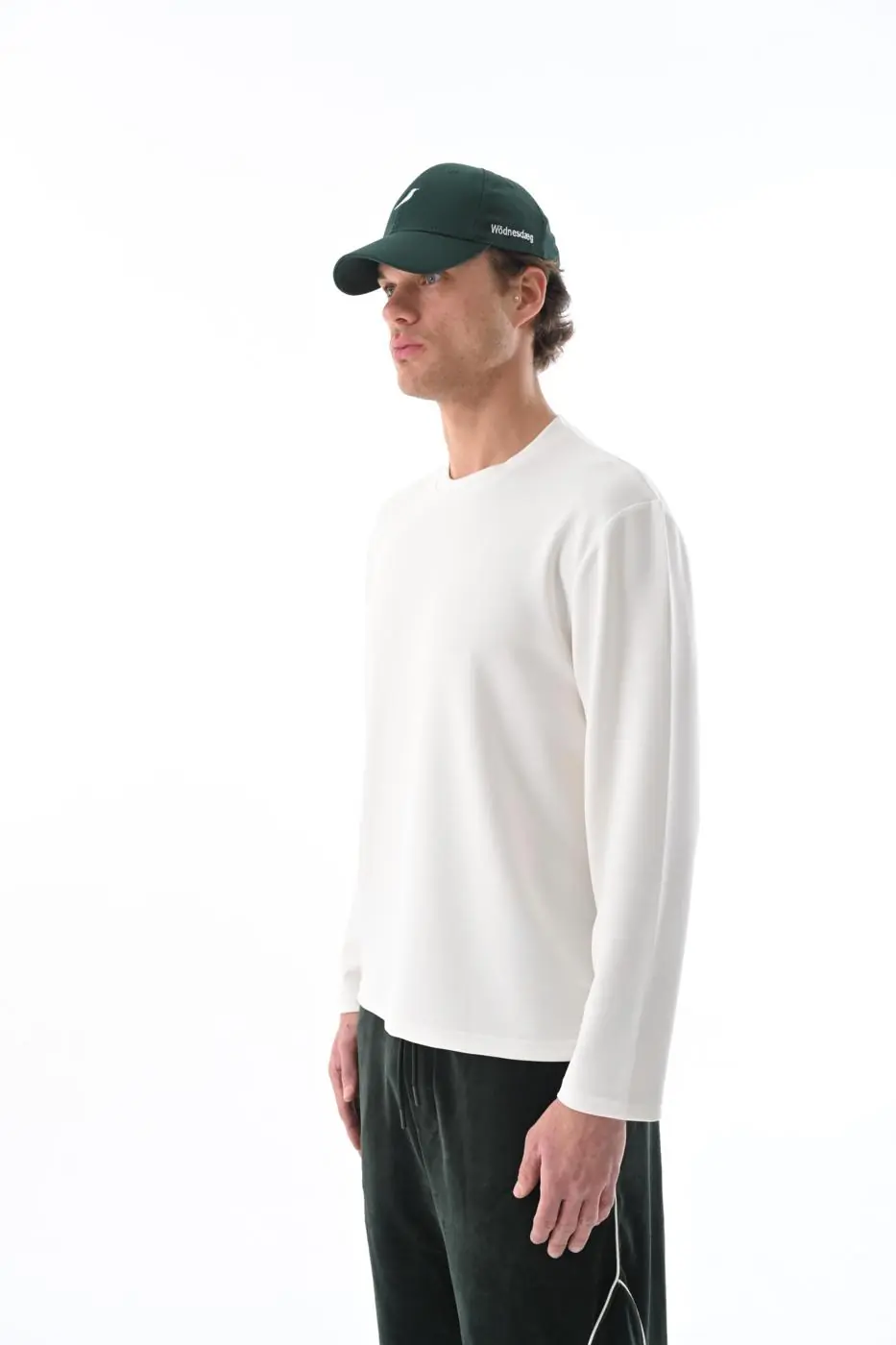 Yeşil Watcher Cap ve Ivory Still Longsleeve giyen model